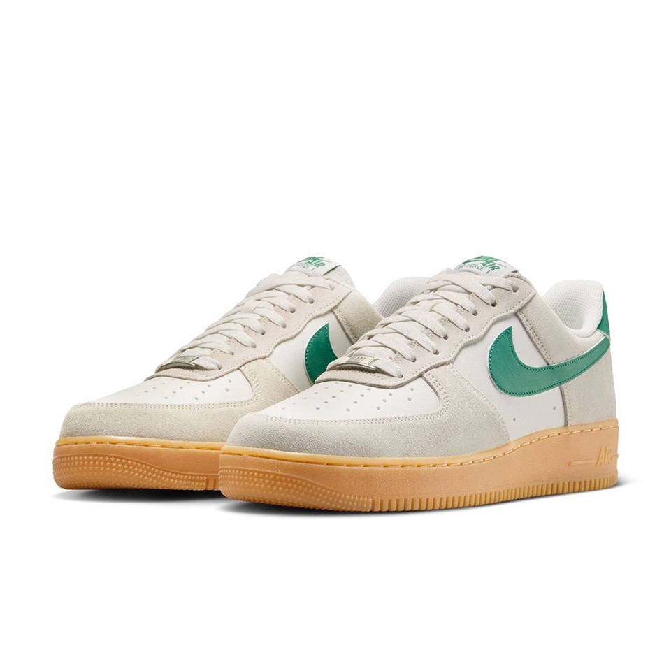 Pair of Nike Air Force 1 '07 LV8 shoes in light grey and white with green Swooshes and gum soles